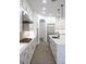 Modern kitchen includes stainless steel appliances, white cabinetry, large island with pendant lighting at 605 Canyon Greens Drive Dr, Las Vegas, NV 89144