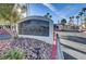 Elegant community entrance sign surrounded by lush landscaping and palm trees under a blue sky at 698 S Racetrack Rd # 1714, Henderson, NV 89015