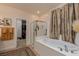 Elegant bathroom featuring a soaking tub, glass-enclosed shower, and a view into a spacious walk-in closet at 7126 Mirkwood Ave, Las Vegas, NV 89178
