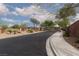 Gated community entrance with brick perimeter walls, desert landscaping, and lush mature trees at 7126 Mirkwood Ave, Las Vegas, NV 89178