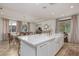 Open-concept kitchen island with marble countertop, farmhouse sink and eat-in dining area at 7126 Mirkwood Ave, Las Vegas, NV 89178