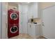 Efficient laundry room with sleek red washer and dryer, white cabinets, and neutral flooring at 7126 Mirkwood Ave, Las Vegas, NV 89178