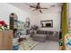 Inviting living room with a comfortable gray sectional sofa, ceiling fan, and decorative wall mirror at 7126 Mirkwood Ave, Las Vegas, NV 89178
