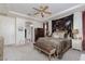 This main bedroom features a tray ceiling, carpet, a decorative tapestry, and a sitting area at 7126 Mirkwood Ave, Las Vegas, NV 89178
