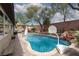 Backyard pool featuring mature trees, lush landscaping, and a waterfall feature at 7126 Mirkwood Ave, Las Vegas, NV 89178