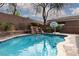 Sparkling backyard pool with rock waterfall feature and basketball hoop, perfect for outdoor fun at 7126 Mirkwood Ave, Las Vegas, NV 89178