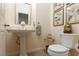 Stylish powder room with a pedestal sink, gold framed botanical prints, and decorative accents at 7126 Mirkwood Ave, Las Vegas, NV 89178