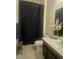 Cozy bathroom featuring a shower with dark curtain, white toilet, vanity and decorative flower arrangement at 782 Omaggio Pl, Henderson, NV 89011