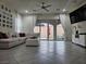 Spacious living room with a large sectional sofa, tiled floors, and sliding glass doors at 782 Omaggio Pl, Henderson, NV 89011