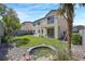 A well-maintained backyard showcases a water feature, manicured lawn, and a home exterior with a balcony at 7821 Red Leaf Dr, Las Vegas, NV 89131