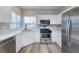 Modern kitchen features white cabinets, stainless steel appliances, quartz countertops and a window at 7836 Pinnochio Ave, Las Vegas, NV 89131