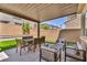 Backyard with artificial turf, a covered patio, and mature landscaping at 8055 Tank Loop St, Las Vegas, NV 89166