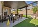 Comfortable backyard patio with lounge seating, dining, and putting green at 8055 Tank Loop St, Las Vegas, NV 89166