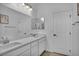 Bright bathroom features a double vanity, an expansive mirror and white cabinetry at 8055 Tank Loop St, Las Vegas, NV 89166