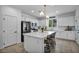 Bright kitchen features white cabinets, stainless steel appliances, and a large center island with bar seating at 8055 Tank Loop St, Las Vegas, NV 89166