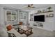 Comfortable living room with large windows, a ceiling fan, and a stylish entertainment center at 8055 Tank Loop St, Las Vegas, NV 89166