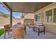 Covered patio with comfortable seating and outdoor dining, overlooking the backyard at 8055 Tank Loop St, Las Vegas, NV 89166