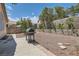Low-maintenance backyard with gravel, block wall, grill, and defined planter beds at 8242 Tribute Ln, Las Vegas, NV 89147