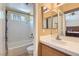 Bathroom featuring shower-tub combination, tile surround, and a large mirror at 8242 Tribute Ln, Las Vegas, NV 89147