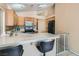 Traditional kitchen featuring wood cabinets, tile countertops, breakfast bar, and modern appliances at 8242 Tribute Ln, Las Vegas, NV 89147