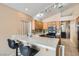Open kitchen features a breakfast bar, tile countertops, wooden cabinets and stainless steel appliances at 8242 Tribute Ln, Las Vegas, NV 89147