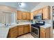 Traditional kitchen featuring wood cabinets, tile countertops, stainless steel appliances, and modern fixtures at 8242 Tribute Ln, Las Vegas, NV 89147
