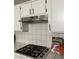 Close-up of a kitchen with a stainless steel stove and white tiled countertops at 9036 Cotton Rose Way, Las Vegas, NV 89134