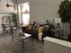 Comfortable living room with a brown sofa, glass coffee table, dining table and a large arched window at 9036 Cotton Rose Way, Las Vegas, NV 89134