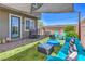 Paver patio and artificial turf backyard featuring a comfortable seating, fire pit, and shade sail for relaxing outdoors at 9208 S Park St, Las Vegas, NV 89178