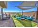 Outdoor oasis with shade sail, cozy seating, fire pit, and artificial turf creating a welcoming and stylish backyard at 9208 S Park St, Las Vegas, NV 89178