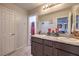 Bathroom with dual sinks, granite countertops, framed mirror, and decorative fixtures at 9208 S Park St, Las Vegas, NV 89178