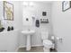 Clean bathroom with pedestal sink, toilet, and decorative wall art for a fresh, modern feel at 9208 S Park St, Las Vegas, NV 89178