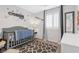 Charming bedroom with a gray crib, patterned rug, and window providing natural light at 9208 S Park St, Las Vegas, NV 89178