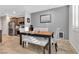 Well-lit dining area with a wooden table, cushioned bench, stylish chairs, and modern decor against gray walls at 9208 S Park St, Las Vegas, NV 89178