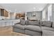 Open-concept living room featuring a comfortable gray sofa, breakfast bar, and dining area with natural light at 9208 S Park St, Las Vegas, NV 89178
