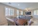 Open-concept living room with dining area features natural light, neutral paint, and a comfortable gray sofa at 9208 S Park St, Las Vegas, NV 89178