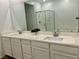 Bathroom with a double sink vanity, large mirror, and a glass-enclosed shower at 965 Nevada State Dr # 39102, Henderson, NV 89002