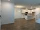 Open-concept living area with wood floors connects to a kitchen featuring white cabinets and an island at 965 Nevada State Dr # 39102, Henderson, NV 89002