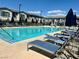 Community pool area with lounge chairs, umbrellas, and clear water at 965 Nevada State Dr # 39102, Henderson, NV 89002