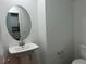 This powder room features pedestal sink, oval mirror, and a view into the kitchen area at 965 Nevada State Dr # 39102, Henderson, NV 89002