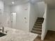 Interior view of kitchen and carpeted staircase with white walls and door at 965 Nevada State Dr # 39102, Henderson, NV 89002