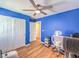 Bright blue bedroom features a ceiling fan, wood floors, and closet at 982 Sable Chase Pl, Henderson, NV 89011