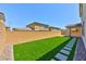 Backyard with artificial grass lawn, stone walkway, and perimeter block wall at 10270 Turkish Pine Ct, Las Vegas, NV 89166