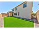 Backyard featuring a synthetic lawn, paver-stone border, and covered patio at 10270 Turkish Pine Ct, Las Vegas, NV 89166