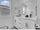 This bathroom has white cabinets, white counters, two mirrored medicine cabinets, and modern black fixtures at 10292 Fragrant Apple Ct, Las Vegas, NV 89141