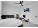 This bedroom has a bed, ceiling fan, mounted television, desk, and neutral decor and paint at 10292 Fragrant Apple Ct, Las Vegas, NV 89141