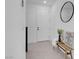 Bright foyer features a white front door, bench, and round mirror, creating an inviting atmosphere at 10292 Fragrant Apple Ct, Las Vegas, NV 89141