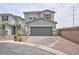 Two-story home with gray stucco, two-car garage and brick paver driveway in a suburban neighborhood at 10292 Fragrant Apple Ct, Las Vegas, NV 89141