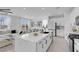 Bright, open kitchen with white countertops and cabinets, flowing into an adjacent living and dining area at 10292 Fragrant Apple Ct, Las Vegas, NV 89141