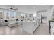 A modern, open-concept kitchen with an island, stainless steel appliances, and an adjacent living area at 10292 Fragrant Apple Ct, Las Vegas, NV 89141